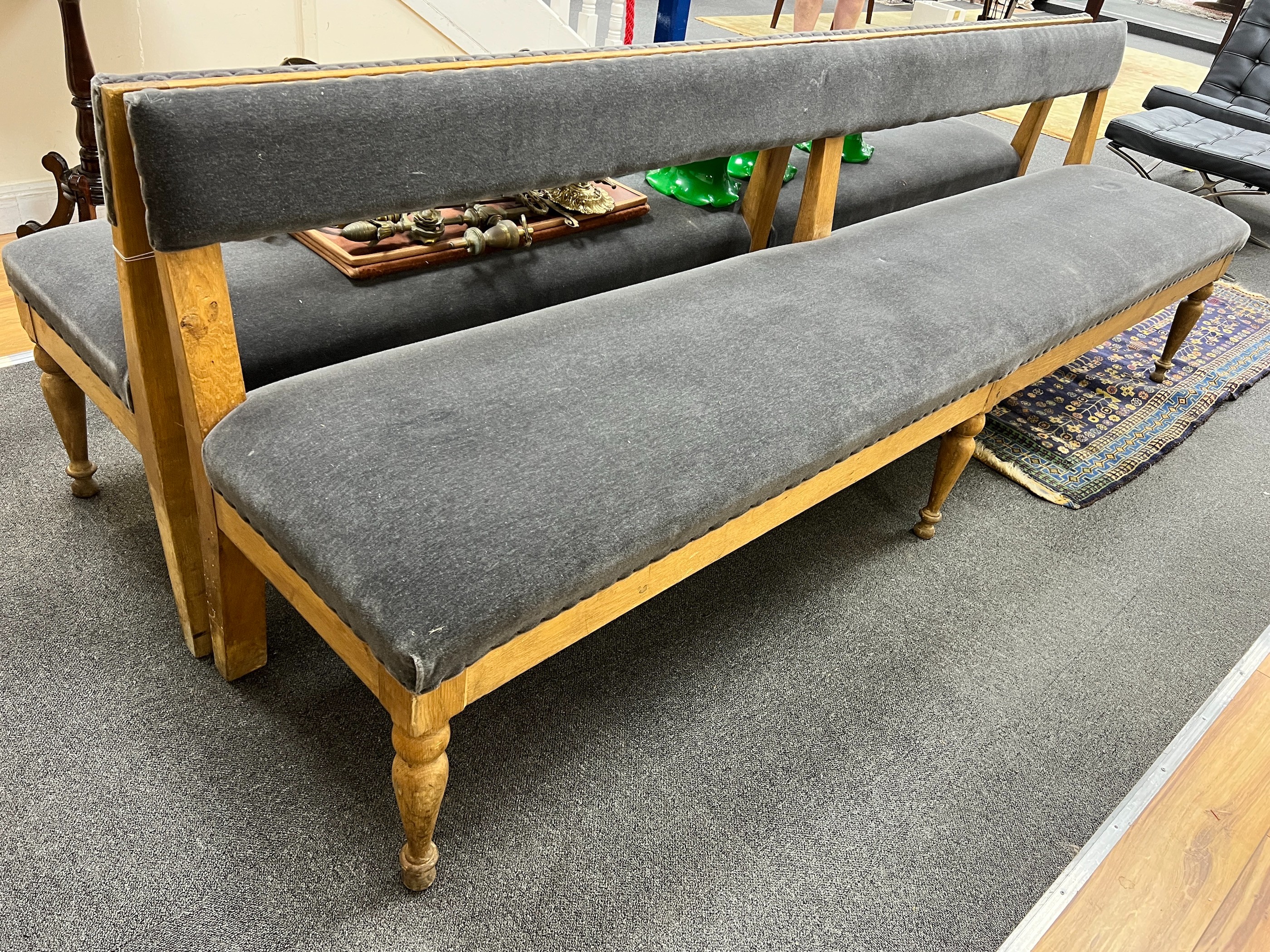A pair of late Victorian pale oak upholstered benches, length 242cm, depth 48cm, height 80cm